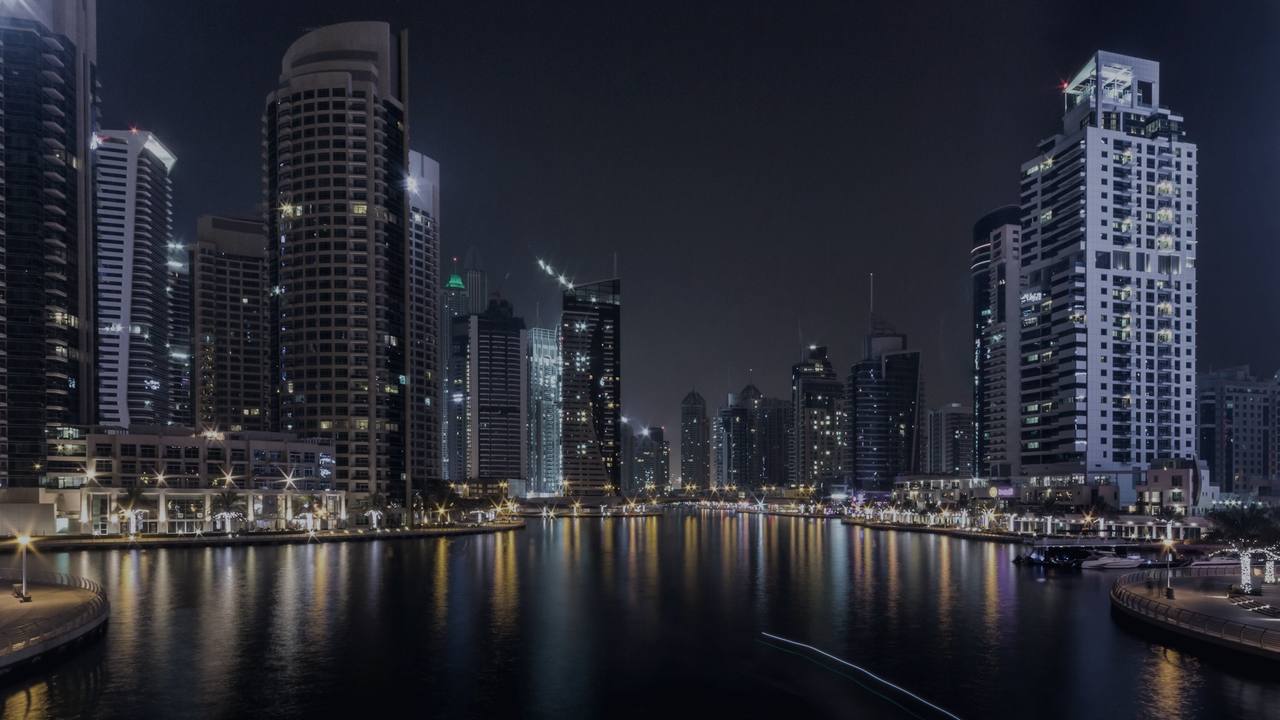 Dubai Marina towers at night, reflected in the water